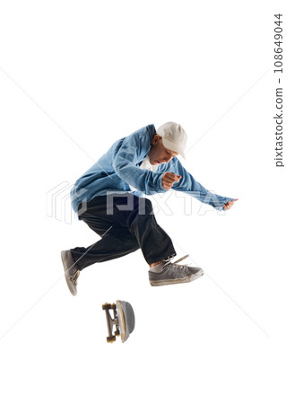 Dynamic image of sportive young man in casual clothes in motion, raining, jumping with skateboard isolated over white background 108649044