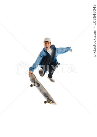 High jump. Active young man in casual clothes in motion, riding skateboard, training isolated over white background High jump. Active young man in casual clothes in motion, riding skateboard, training isolated over white background 108649048