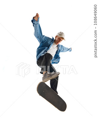 Dynamic image of young man in casual clothes in motion, training, skateboarding isolated over white background 108649060