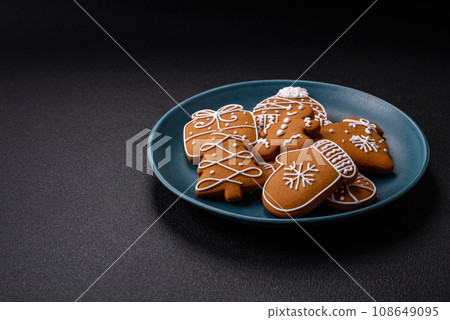 Beautiful Christmas gingerbread cookies of different colors on a ceramic plate 108649095