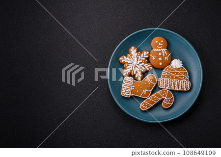 Beautiful Christmas gingerbread cookies of different colors on a ceramic plate Beautiful Christmas gingerbread cookies of different colors on a ceramic plate 108649109