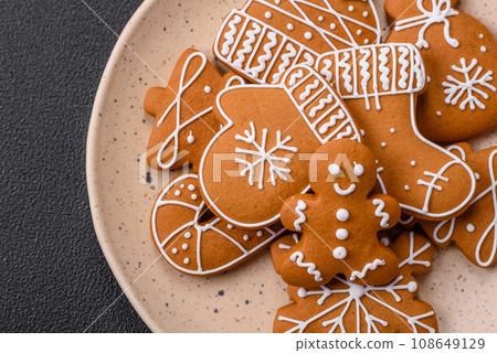 Beautiful Christmas gingerbread cookies of different colors on a ceramic plate 108649129