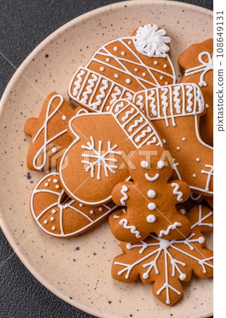 Beautiful Christmas gingerbread cookies of different colors on a ceramic plate Beautiful Christmas gingerbread cookies of different colors on a ceramic plate 108649131