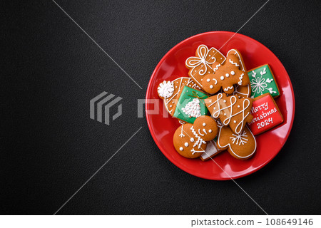 Beautiful Christmas gingerbread cookies of different colors on a ceramic plate 108649146