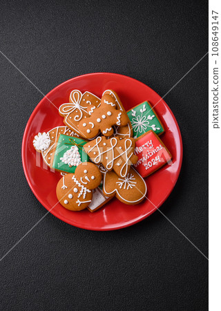 Beautiful Christmas gingerbread cookies of different colors on a ceramic plate 108649147