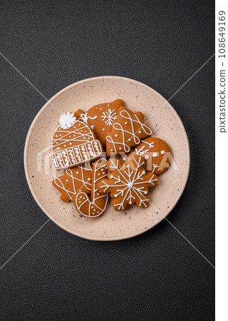 Beautiful Christmas gingerbread cookies of different colors on a ceramic plate 108649169