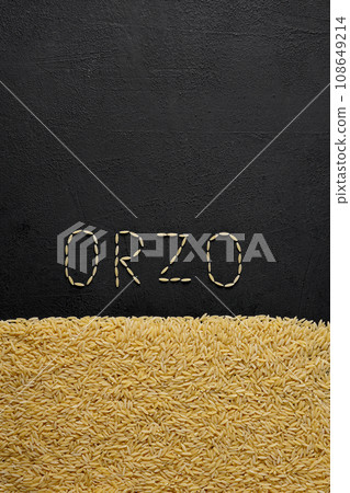 Italian pasta orzo on a black background, top view. Close-up of hard pasta in the shape of small rice. 108649214