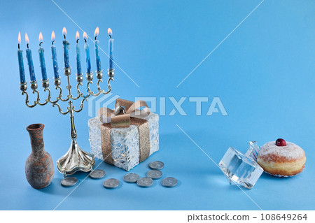 Jewish holiday Hanukkah with menorah, traditional Candelabra, donut and dreidel, spinning top. 108649264