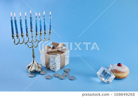Jewish holiday Hanukkah with menorah, traditional Candelabra, donut and dreidel, spinning top. 108649268