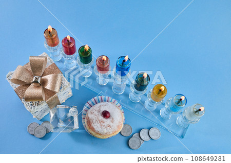 Jewish holiday Hanukkah with menorah, traditional Candelabra, donut and dreidel, spinning top. Jewish holiday Hanukkah with menorah, traditional Candelabra, donut and dreidel, spinning top. 108649281
