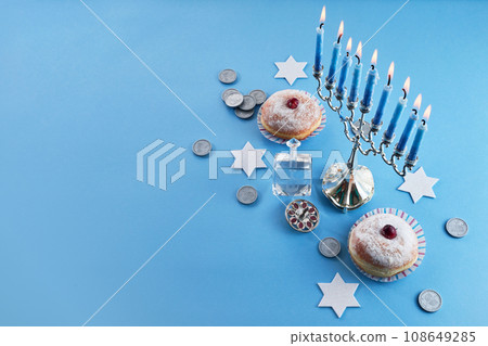 Jewish holiday Hanukkah with menorah, traditional Candelabra, donut and dreidel, spinning top. Jewish holiday Hanukkah with menorah, traditional Candelabra, donut and dreidel, spinning top. 108649285