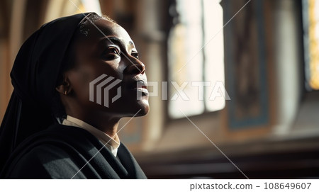 Middle aged African American nun praying 108649607