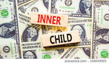 Inner child symbol. Concept words Inner child on beautiful wooden block. Beautiful background from dollar bills. Dollar bills. Psychological, motivational inner child concept. Copy space. Inner child symbol. Concept words Inner child on beautiful wooden block. Beautiful background from dollar bills. Dollar bills. Psychological, motivational inner child concept. Copy space. 108649993
