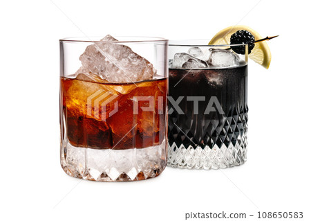 Set of Black Russian cocktails in crystal-clear glass sits against a white background 108650583