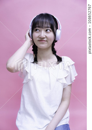 Young woman listening to music on smartphone with headphones 108652767