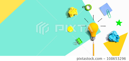 Brainstorming concept with a light bulb and school supplies - Flat lay 108653296