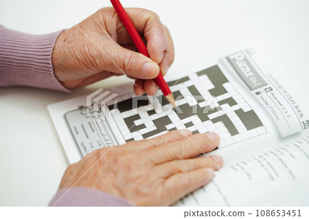 Bangkok, Thailand - May 15, 2022 elderly woman playing sudoku puzzle game for treatment dementia prevention and Alzheimer disease. Bangkok, Thailand - May 15, 2022 elderly woman playing sudoku puzzle game for treatment dementia prevention and Alzheimer disease. 108653451