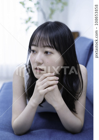Young woman lying on the sofa and relaxing Young woman lying on the sofa and relaxing 108653858