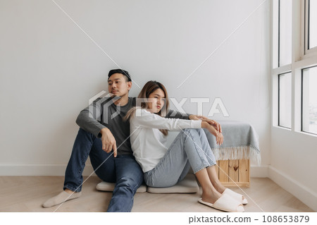 Boring and tired faces of lover sit on the floor of empty room. 108653879