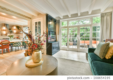 a living room with couches, chairs and a coffee table in the center of the room is decorated with flowers 108654195