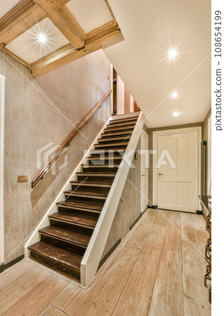 an empty room with wood flooring and white walls, stairs leading up to the second floor in this house an empty room with wood flooring and white walls, stairs leading up to the second floor in this house 108654199