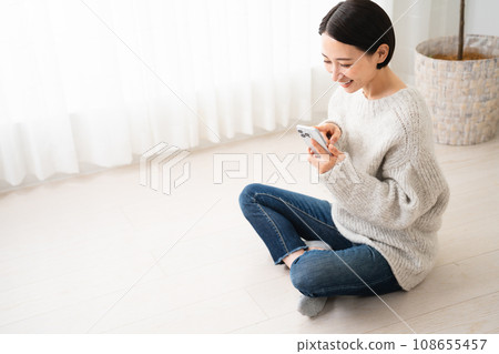 Young woman operating a smartphone - lifestyle image Young woman operating a smartphone - lifestyle image 108655457