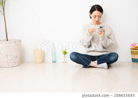 操作智慧型手機的年輕女性 — 生活方式形象 操作智慧型手機的年輕女性 — 生活方式形象 108655693