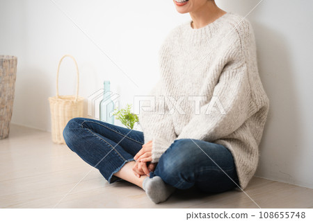 Young woman sitting leaning against the wall - lifestyle image 108655748