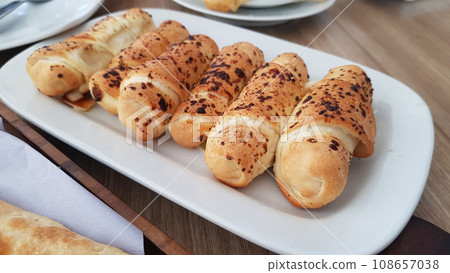 Delicious baked cheese rolls, baked crunchy cheese bread on an catering event, selected focus, cheese wrapped in bread and baked Delicious baked cheese rolls, baked crunchy cheese bread on an catering event, selected focus, cheese wrapped in bread and baked 108657038