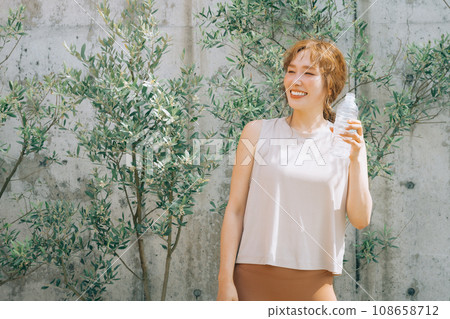 A woman with a plastic bottle of water/mineral water, exercise, diet, hydration, hydrogen water, detox A woman with a plastic bottle of water/mineral water, exercise, diet, hydration, hydrogen water, detox 108658712
