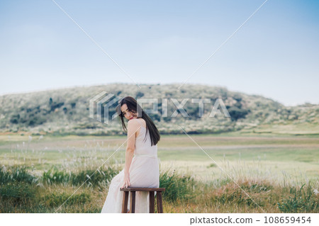 Beauty image: A woman sitting on a chair in nature Beauty image: A woman sitting on a chair in nature 108659454
