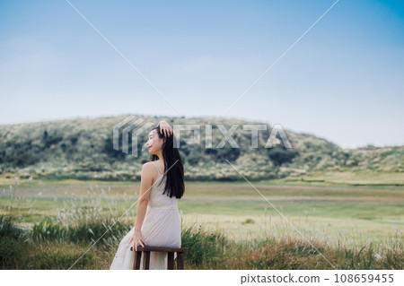 Beauty image: A woman sitting on a chair in nature Beauty image: A woman sitting on a chair in nature 108659455