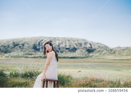 Beauty image: A woman sitting on a chair in nature 108659456