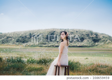 Beauty image: A woman sitting on a chair in nature Beauty image: A woman sitting on a chair in nature 108659459