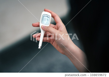 A woman with a fever and measuring her body temperature A woman with a fever and measuring her body temperature 108659672