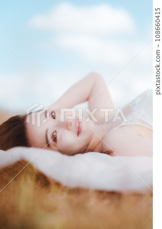 Beauty image of a woman lying on a meadow Beauty image of a woman lying on a meadow 108660415