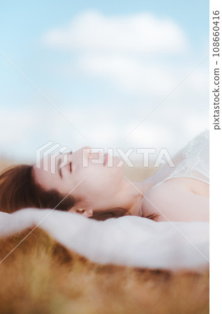 Beauty image of a woman lying on a meadow Beauty image of a woman lying on a meadow 108660416