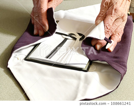 一位老婦人的手在福薩包裹著一個禮物袋 108661241