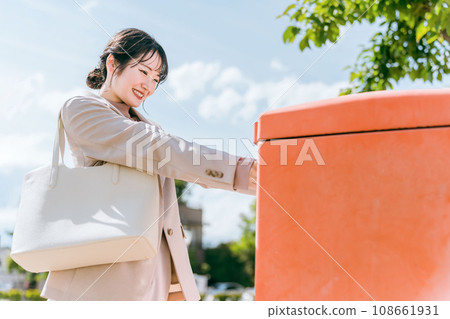 一位女士將一封信放入信箱(郵寄、運送、申請) 一位女士將一封信放入信箱(郵寄、運送、申請) 108661931