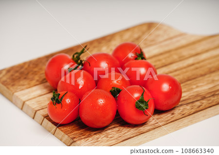 Cherry tomatoes on a wooden cutting board Cherry tomatoes on a wooden cutting board 108663340