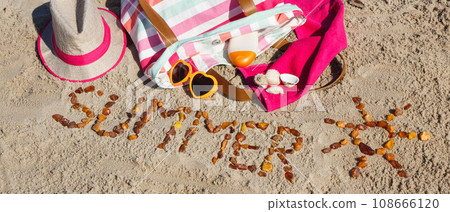 Inscription summer with shape of sun made of amber stones and accessories for relax or sunbathing Inscription summer with shape of sun made of amber stones and accessories for relax or sunbathing 108666120