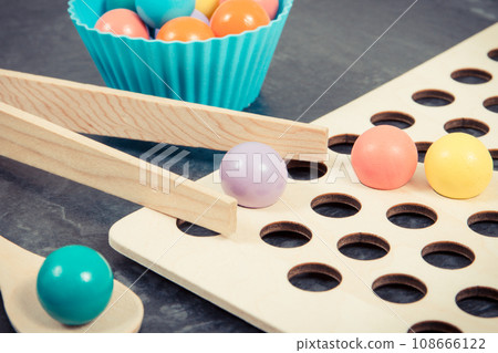 Colorful balls with spoon and tongs. Development of kids motor skills Colorful balls with spoon and tongs. Development of kids motor skills 108666122
