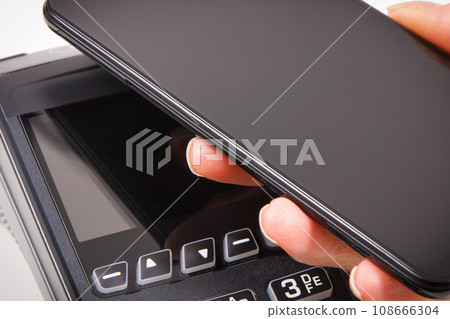 Hand of woman using payment terminal and smartphone to cashless paying. Finance concept 108666304