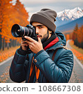 A dark-skinned male photographer with a beard in a hat and a winter jacket. 108667308