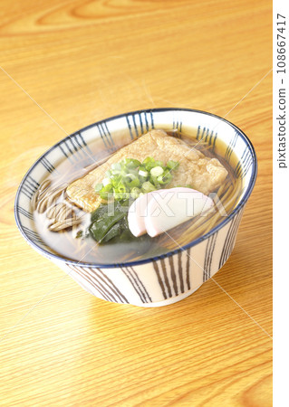 Hot fox soba with fried tofu, kamaboko, wakame, and green onions 108667417