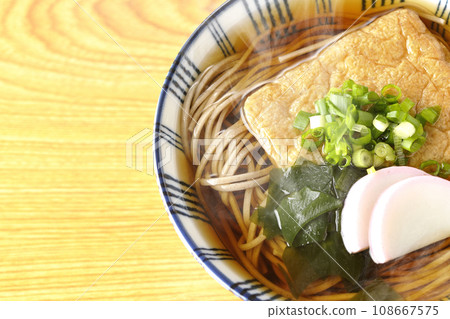 頭頂上放著熱騰騰的狐狸蕎麥麵,上面放著炸豆腐、魚糕、裙帶菜和大蔥。 頭頂上放著熱騰騰的狐狸蕎麥麵,上面放著炸豆腐、魚糕、裙帶菜和大蔥。 108667575