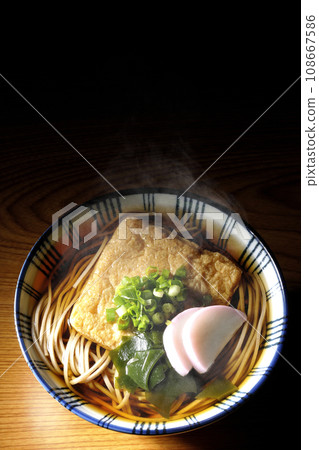 頭頂上放著熱騰騰的狐狸蕎麥麵,上面放著炸豆腐、魚糕、裙帶菜和大蔥。 頭頂上放著熱騰騰的狐狸蕎麥麵,上面放著炸豆腐、魚糕、裙帶菜和大蔥。 108667586