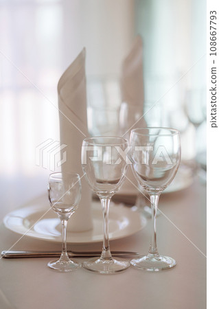 Three empty glasses for alcoholic beverages of vodka, wine and champagne are on the table 108667793