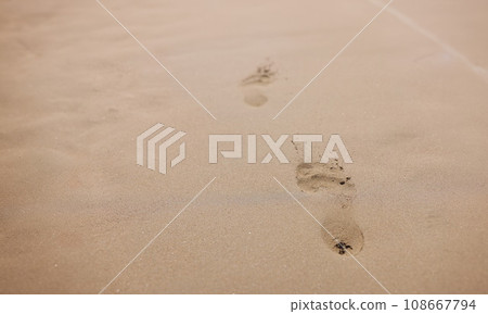 Closeup of footprints from bare feet on sand 108667794