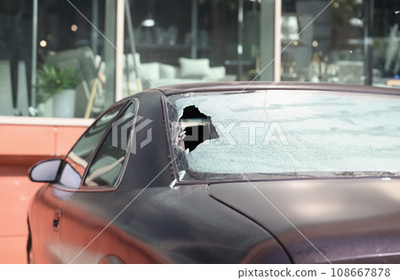Closeup of broken rear glass of black car 108667878